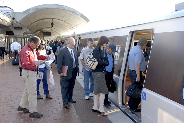 Passengers board the Orange Line at the New Carrollton Metrorail station.