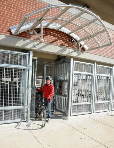 Man with bicycle at secure parking facility